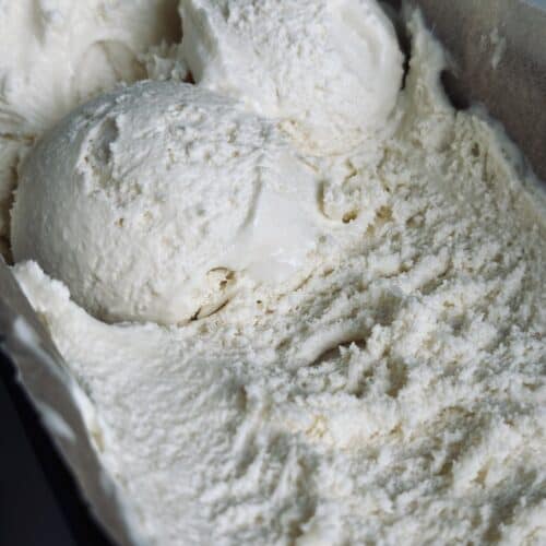 Scoops of vanilla ice cream in a metal pan.