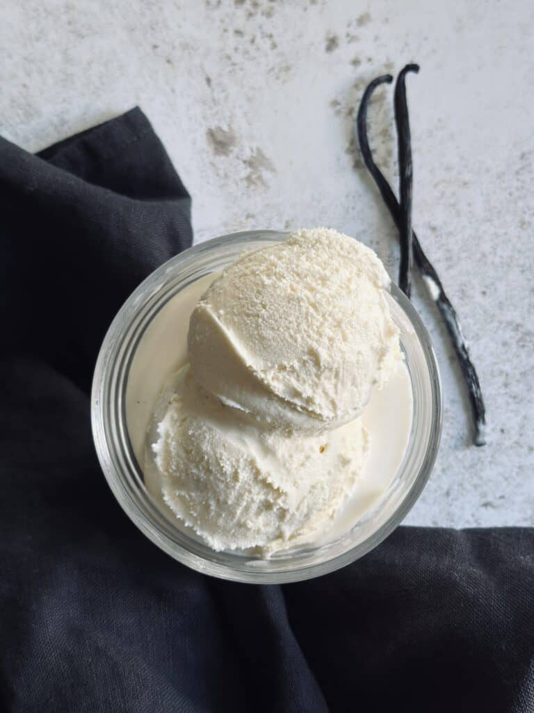 A glass cup with two scoops of homemade vanilla ice cream.