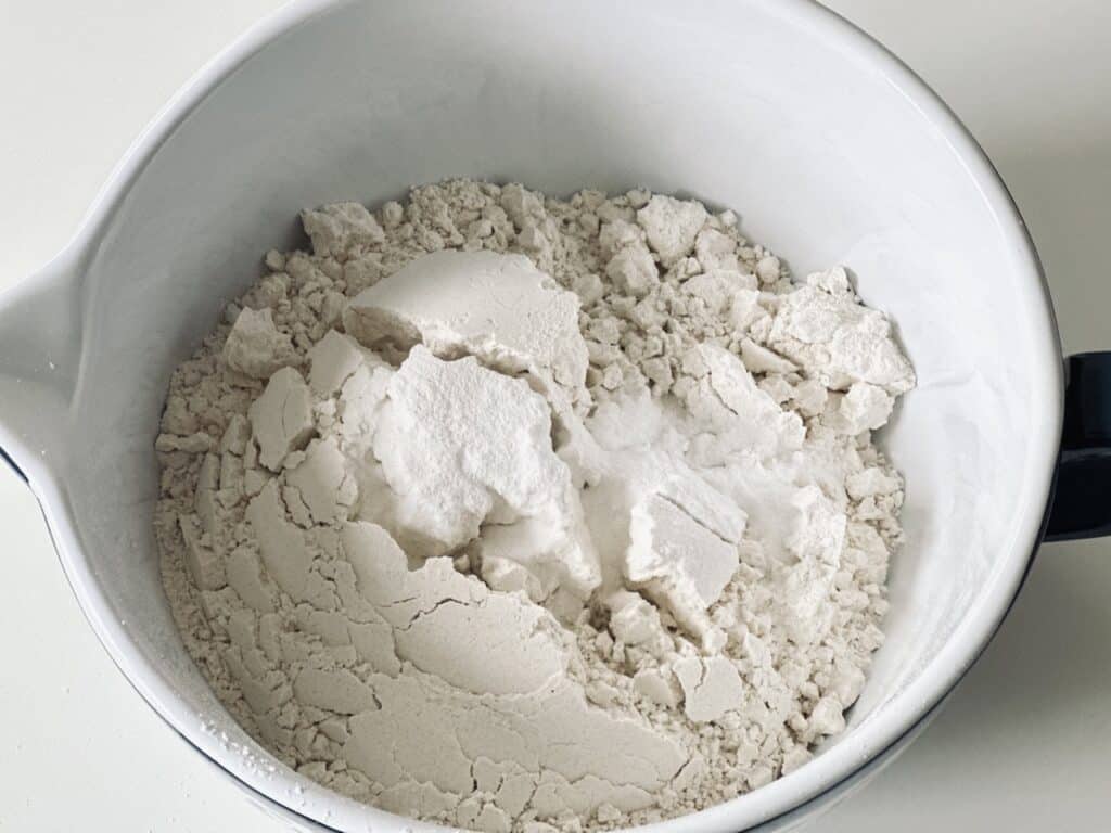 A large bowl with flour, baking soda, and baking powder.