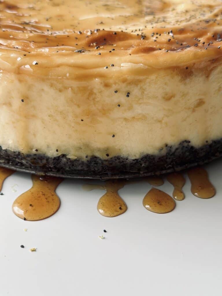 A close up of cheesecake that has been drizzled with a honey glaze