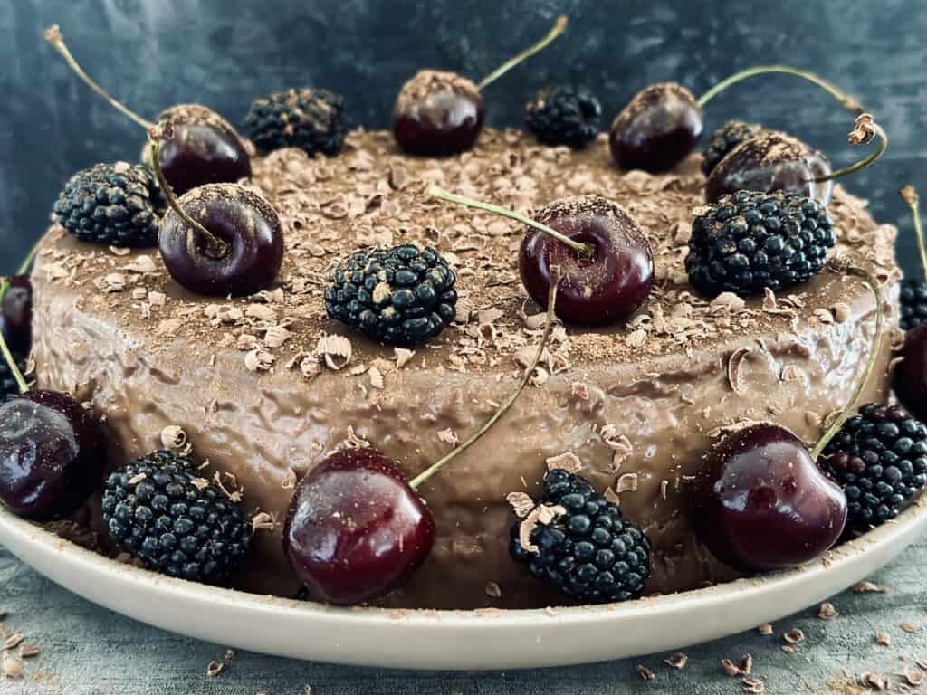 A cherry and blackberry chocolate cheesecake on a plate.
