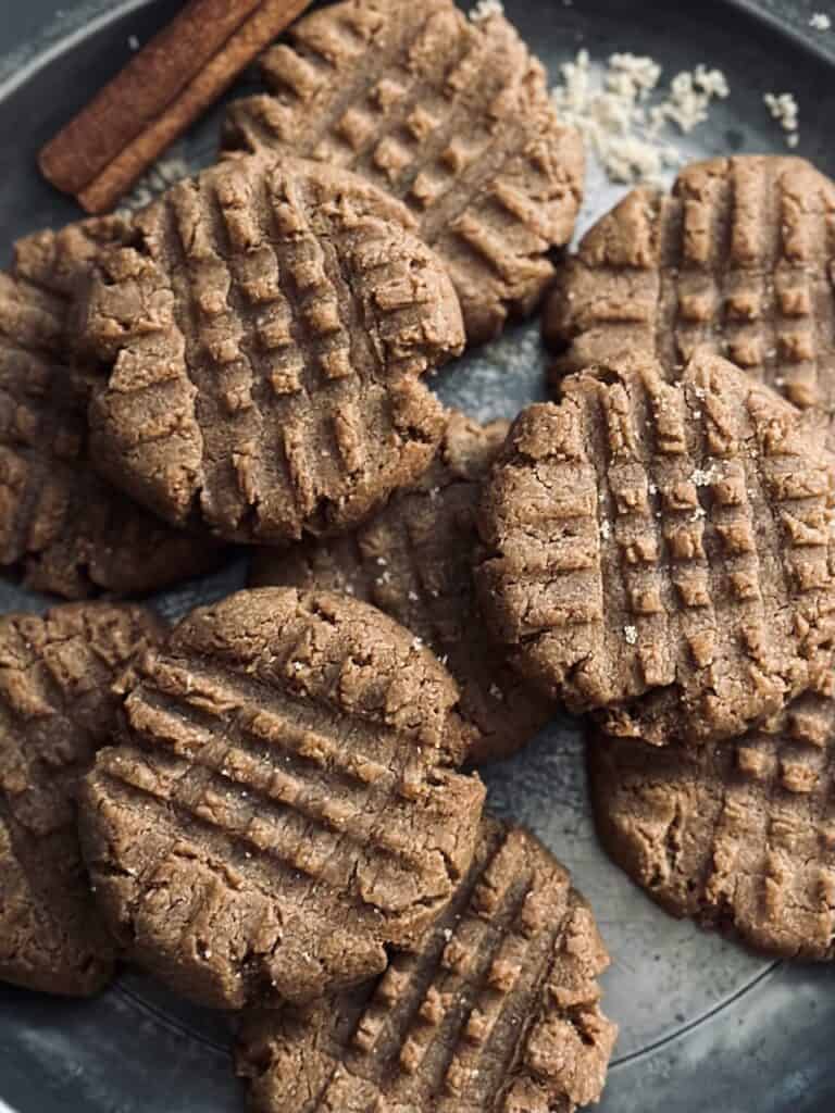 Peanut butter cookies with criss cross pattern stacked on a plate