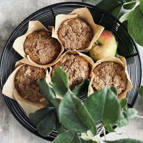 A basket full of apple and raisin rye muffins.