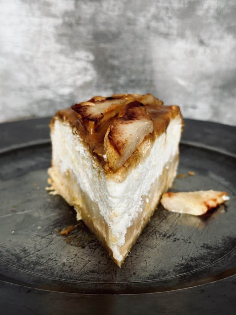 A close up of a slice of pear and ricotta cheesecake.
