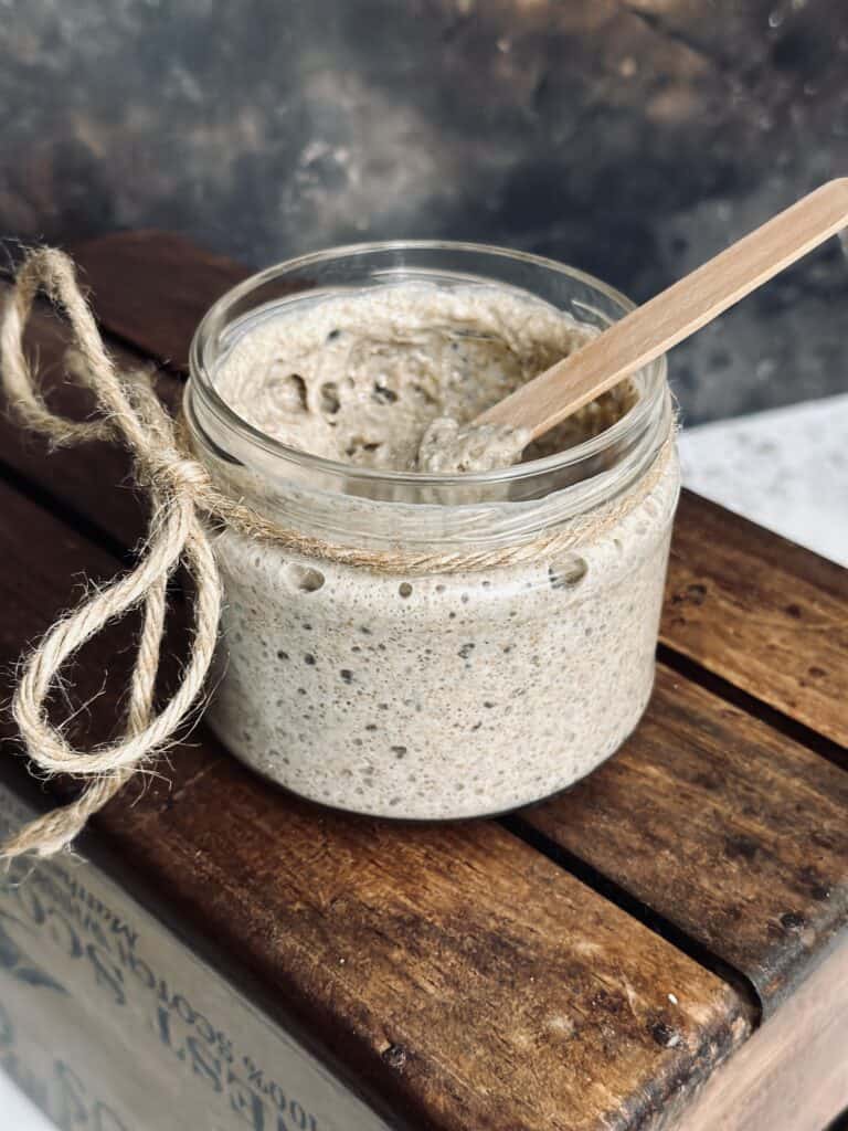 Mixing in a sourdough starter with a wooden spoon