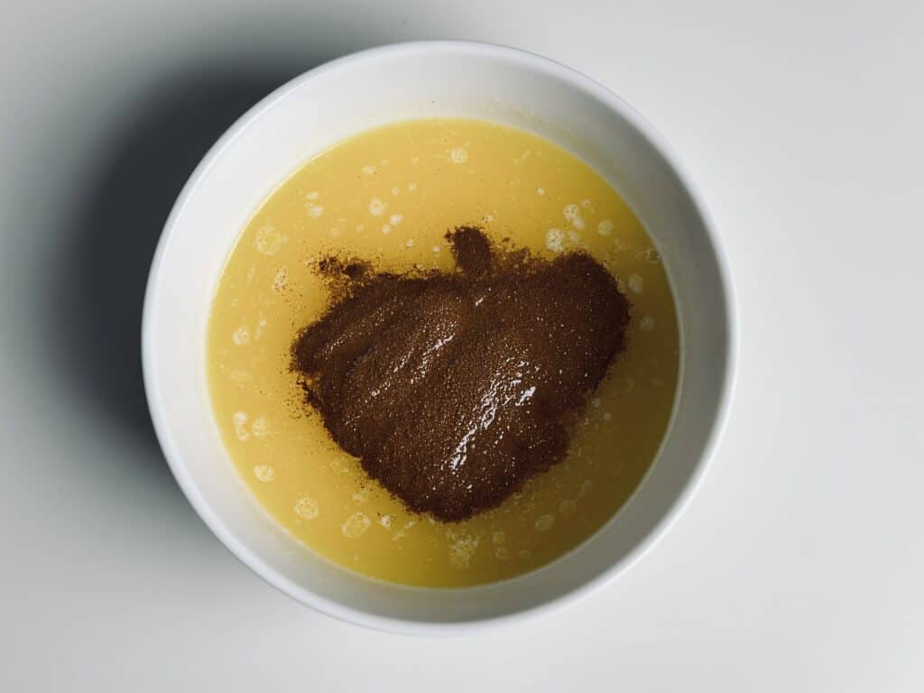 A bowl with melted butter and instant coffee powder.