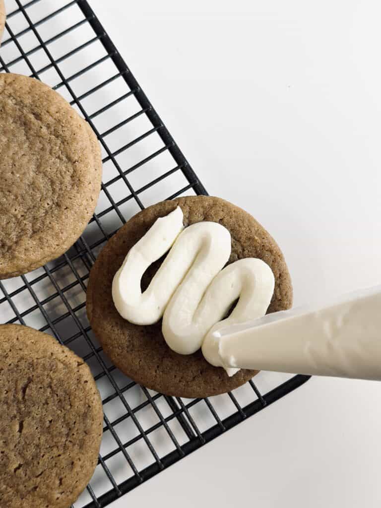 Pipping mascarpone cream on a cookie.