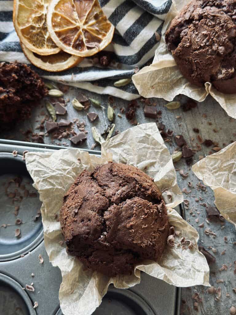 Sourdough double-chocolate muffin with orange and cardamom in a muffin tin.