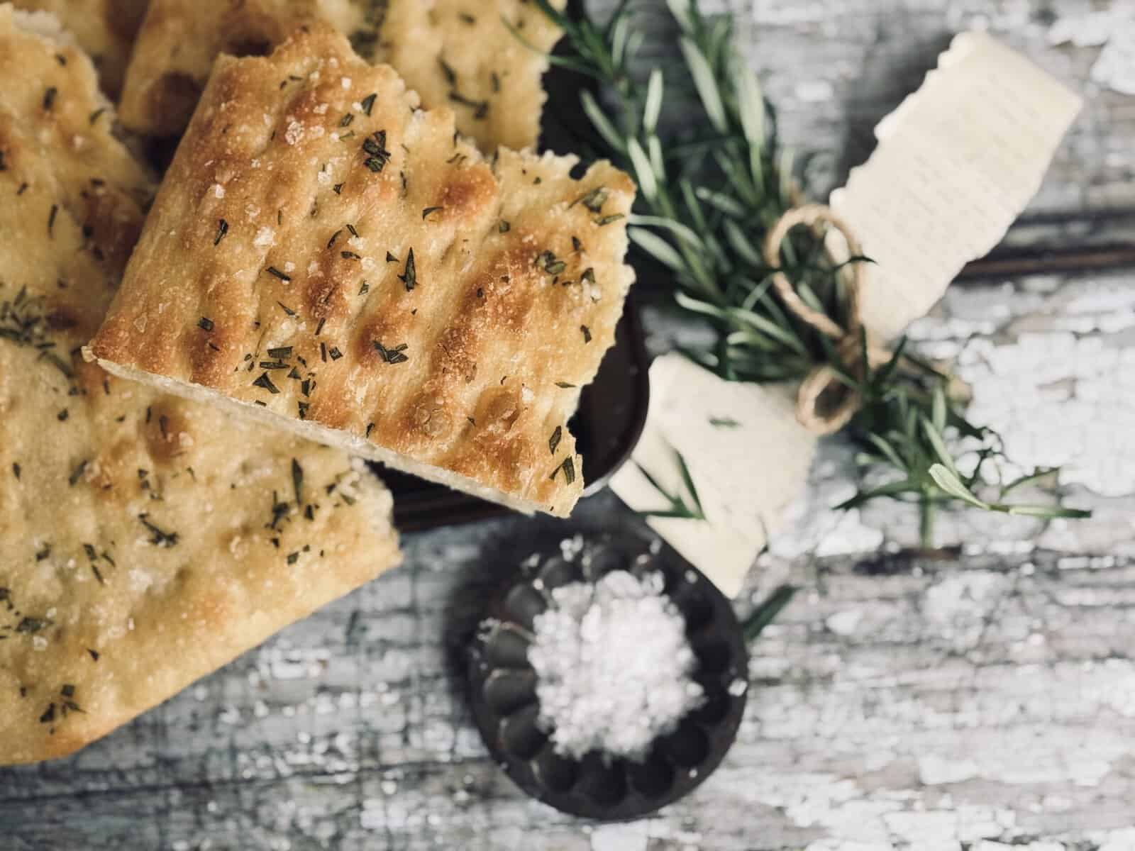 Sourdough focaccia chunks sprinkled with fresh rosemary and sea salt flakes.