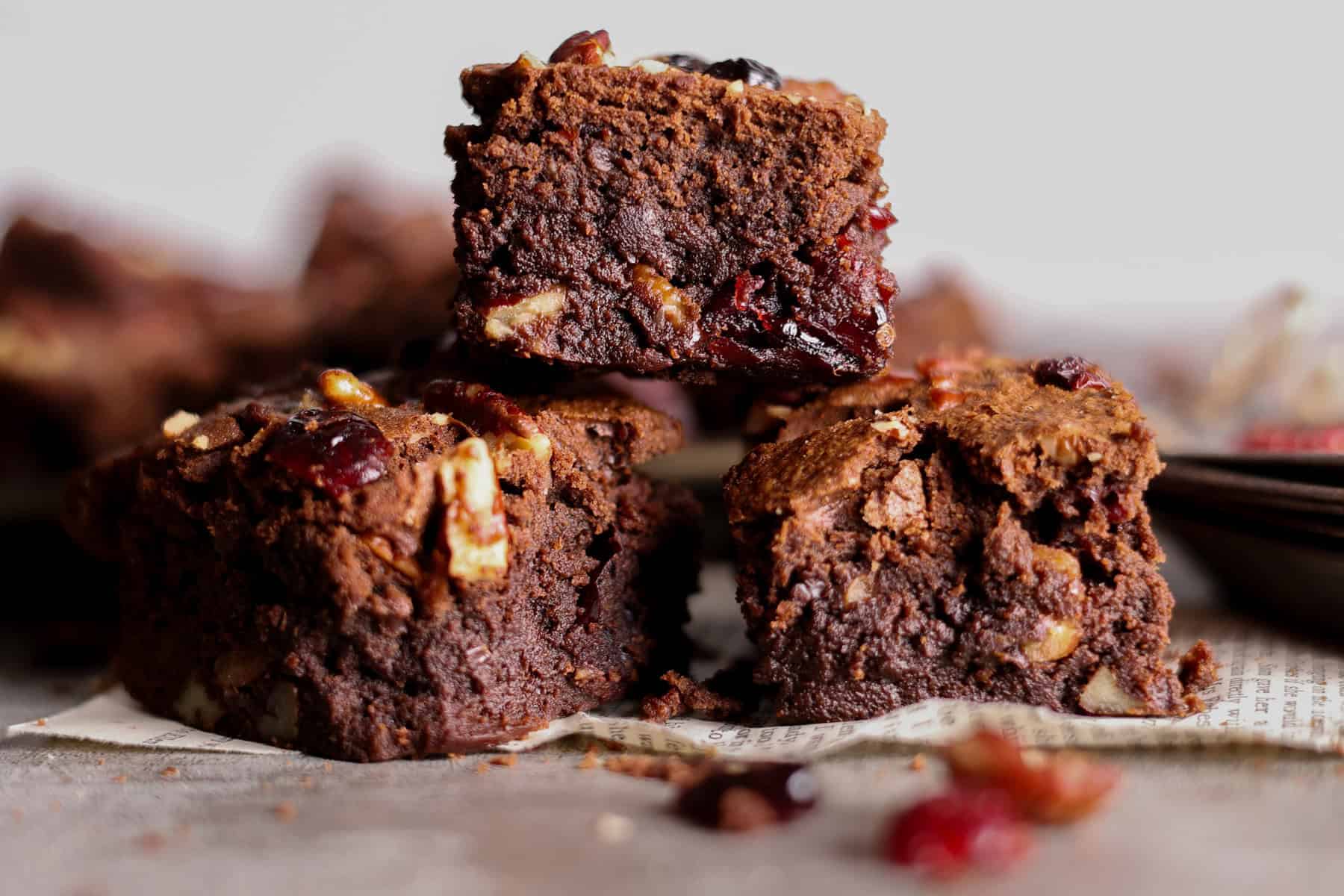 A close up of sourdough chocolate brownies with cranberries and pecans.