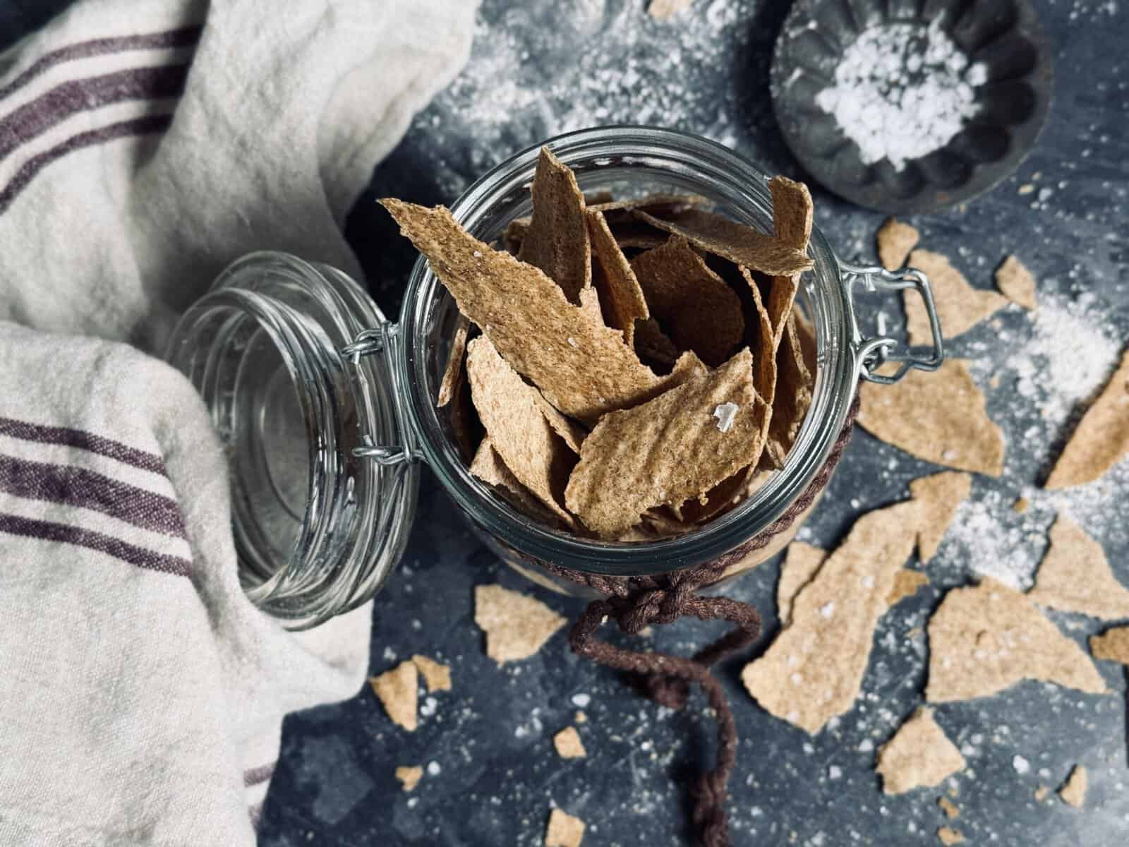 A glass jar full of sourdough crackers.