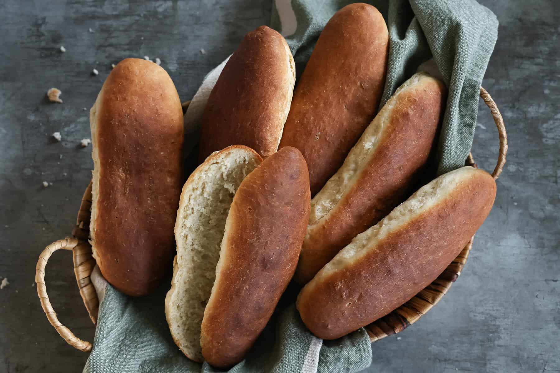 A basket full of sourdough hot dog buns.