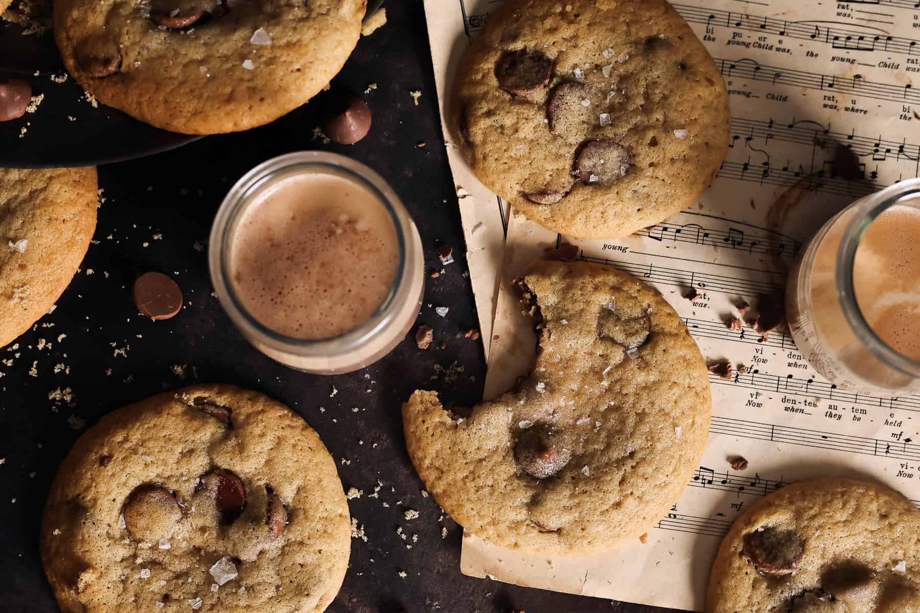 Sourdough chocolate chip cookies on a table served with chocolate milk.