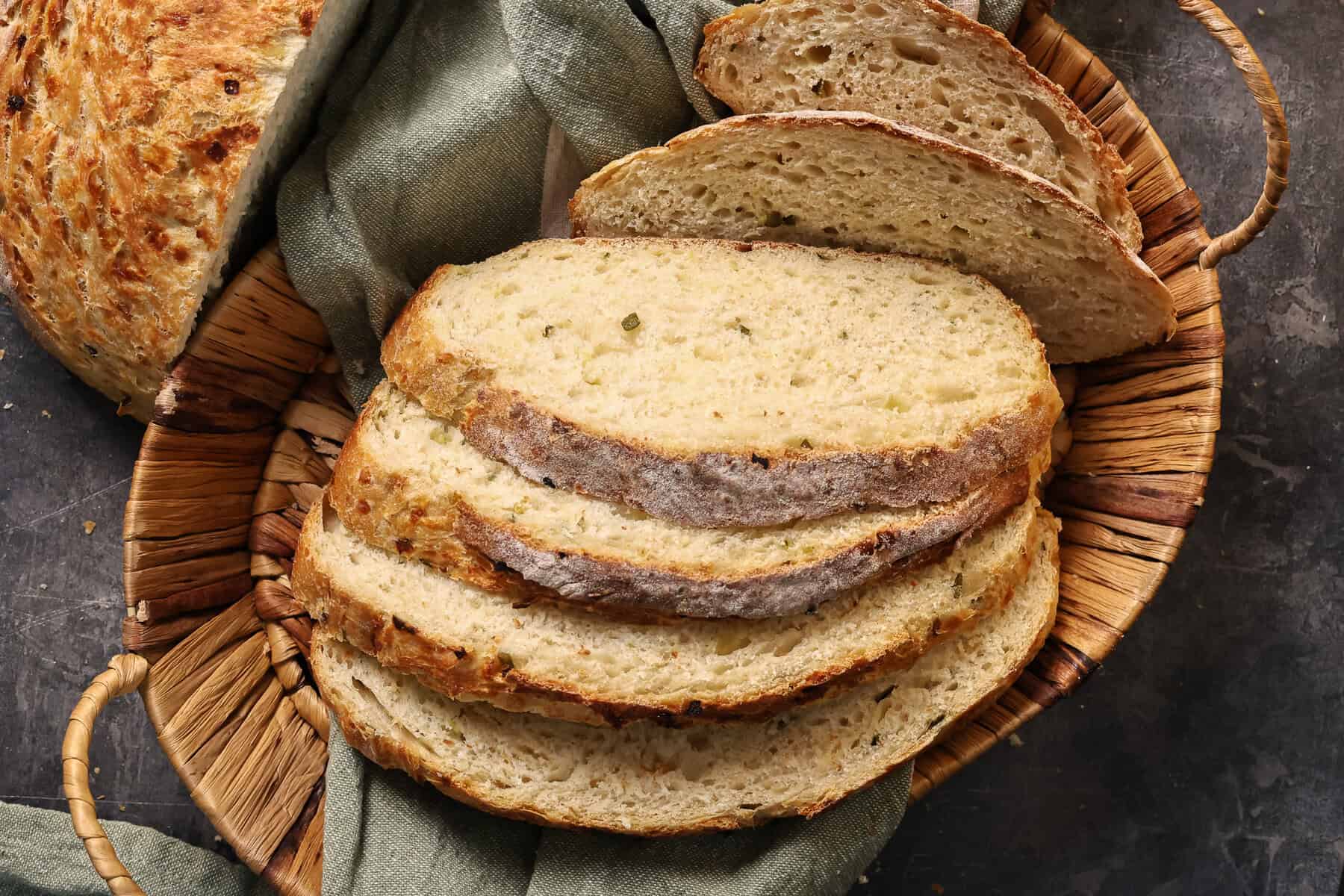 Sliced dill pickle cheddar bread in a bread basket.