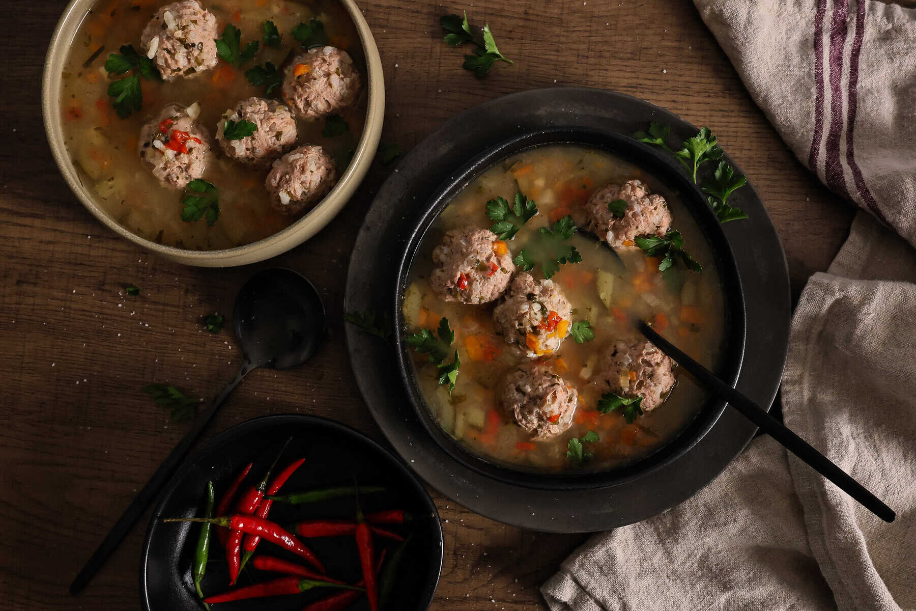 Two bowls of sour pork meatball soup with vegetables.