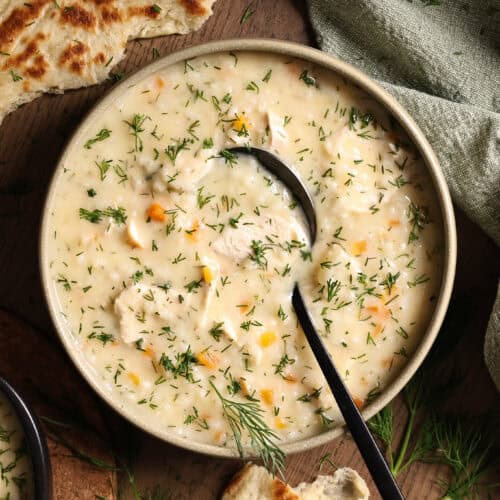 A bowl of Greek-style creamy chicken and rice soup topped with fresh dill.