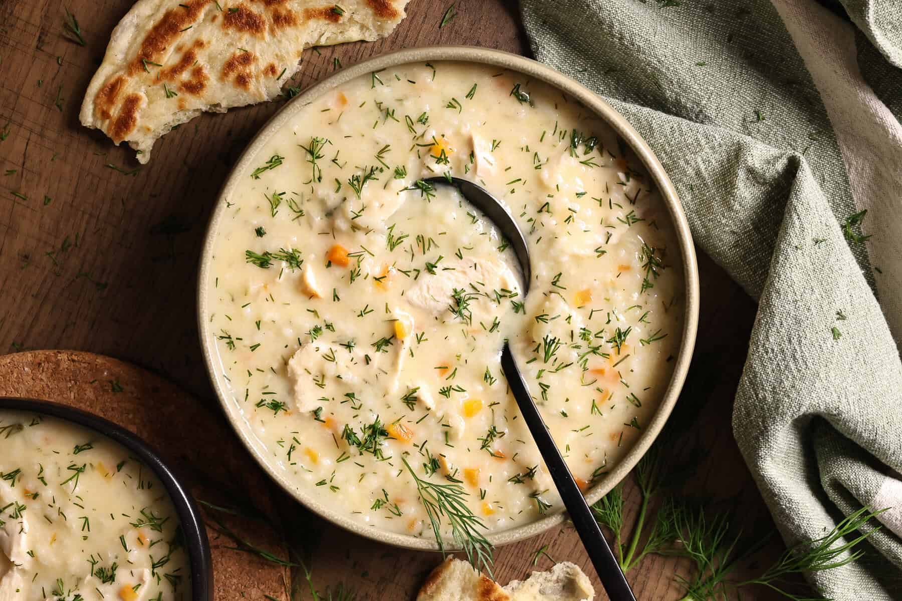 A bowl of Greek-style creamy chicken and rice soup topped with fresh dill.