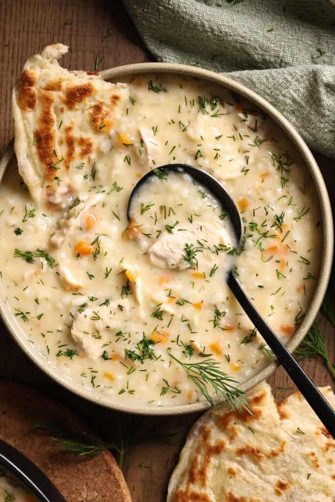 A bowl of Greek chicken soup served with flatbread