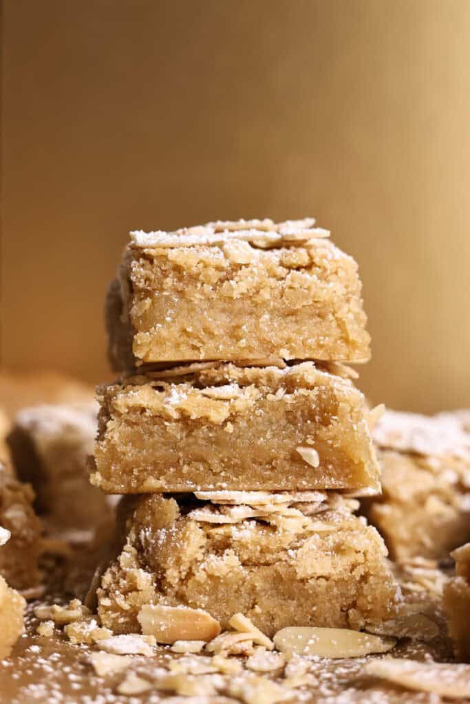 3 almond croissant cookie bars stacked on top of each other.
